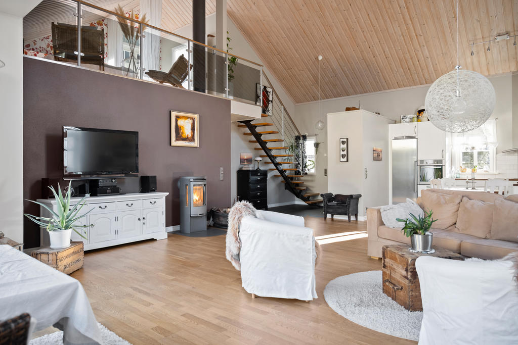 Vardagsrum och kök i öppen planlösning med vy mot hallen och över plan.