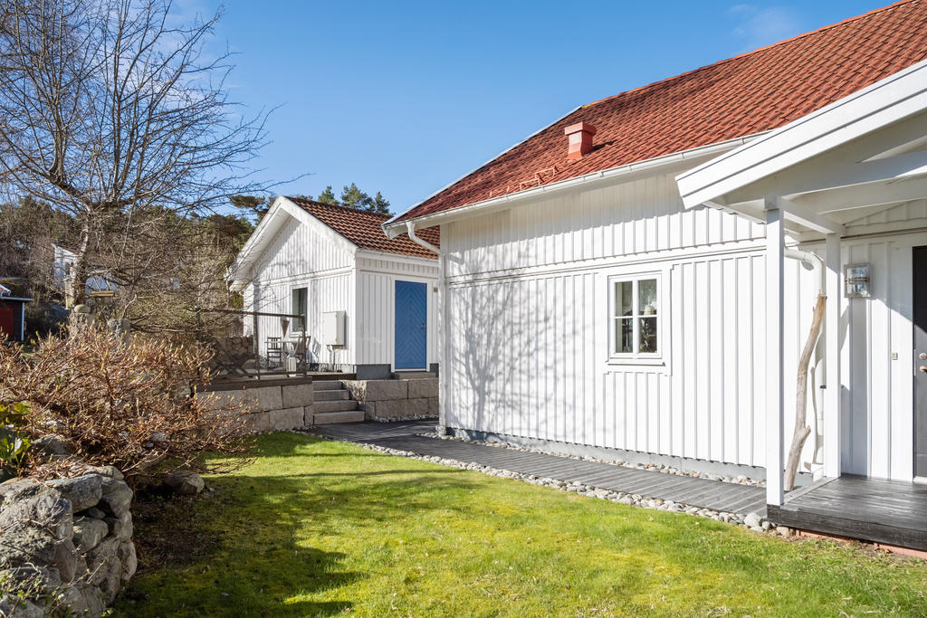 Entrésidan huset och skymt av gästhus som även har en trevlig frukosthörna terrass utanför huset.