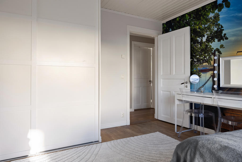 Master bedroom med stor skjutdörrsgarderob.