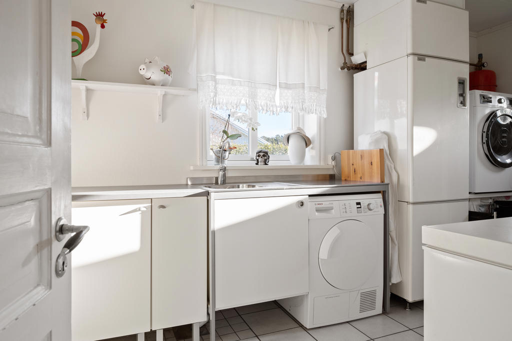 Tvättstuga med tvättmaskin, torktumlare, diskho , frysbox och bergvärmepanna.