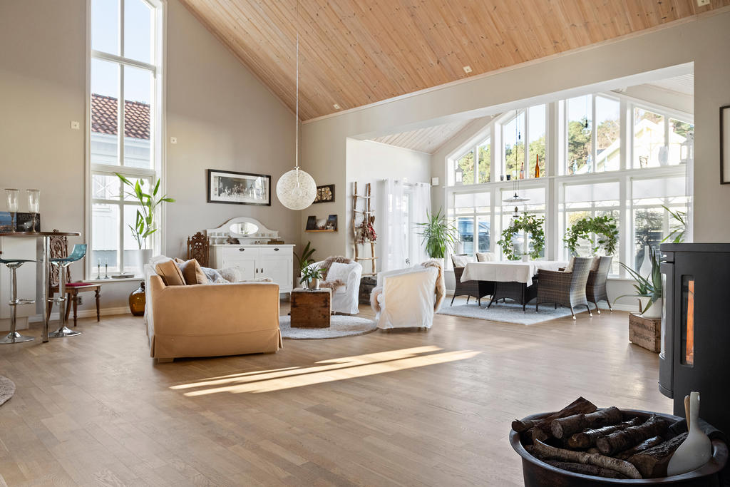 Vardagsrummet har en underbar rymd och högt i tak, stora vackra fönster och en värmande kamin.