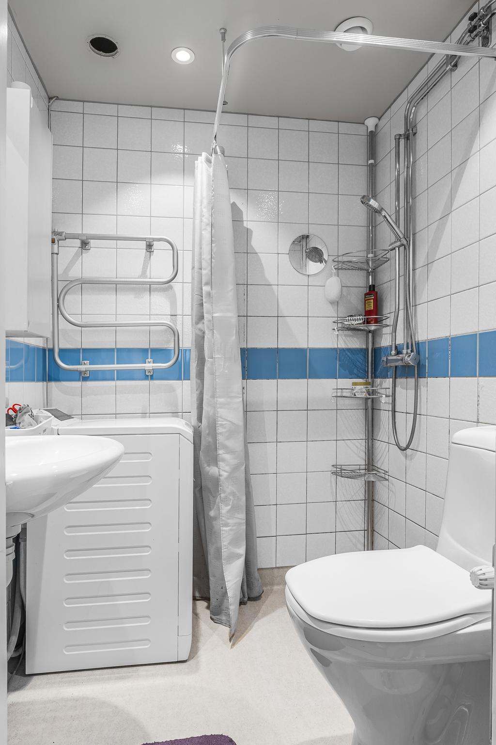 Duschrum med kaklade väggar och spotlights i taket