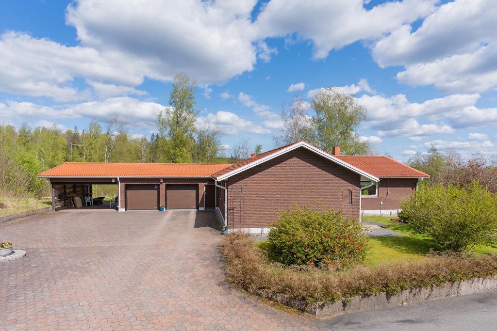 Dubbelgarage, carport och stor stenlagd uppställningsplats för bilar