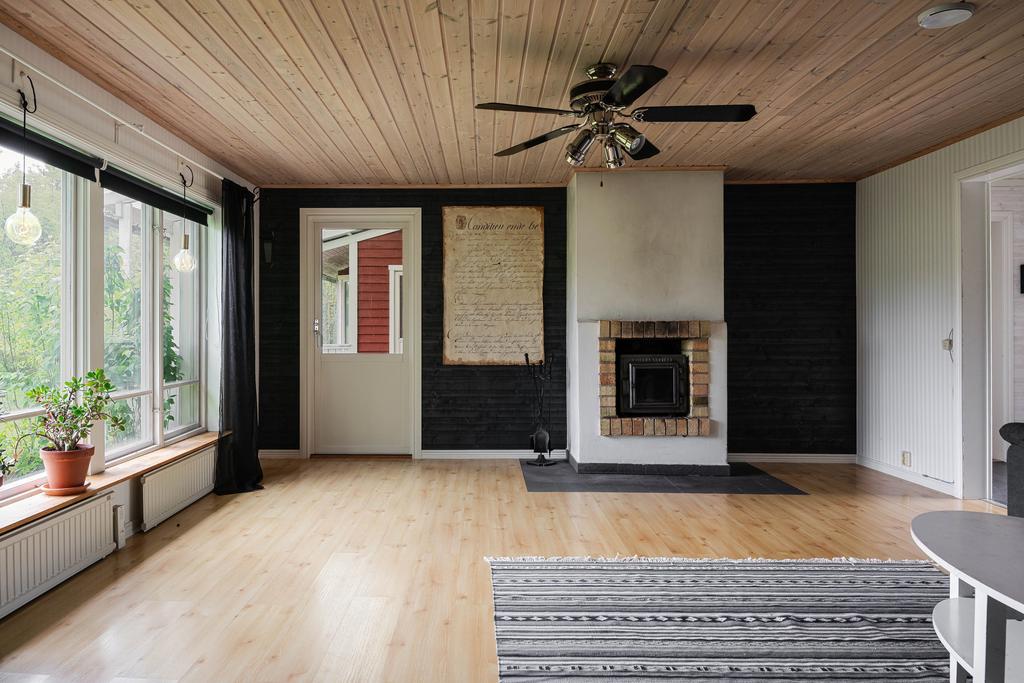 Vardagsrummet har utgång till verandan och en öppen spis med insats