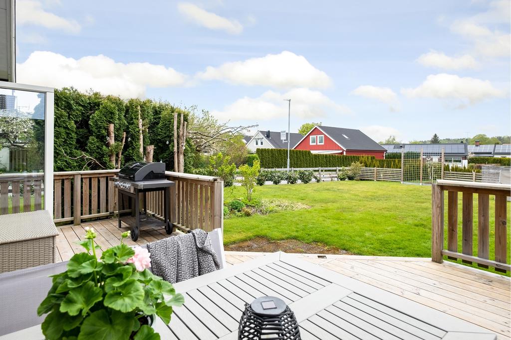 Den trevliga uteplatsen badar i många soltimmar och leder ut till den plana trädgården, perfekt för barnens lek och äventyr