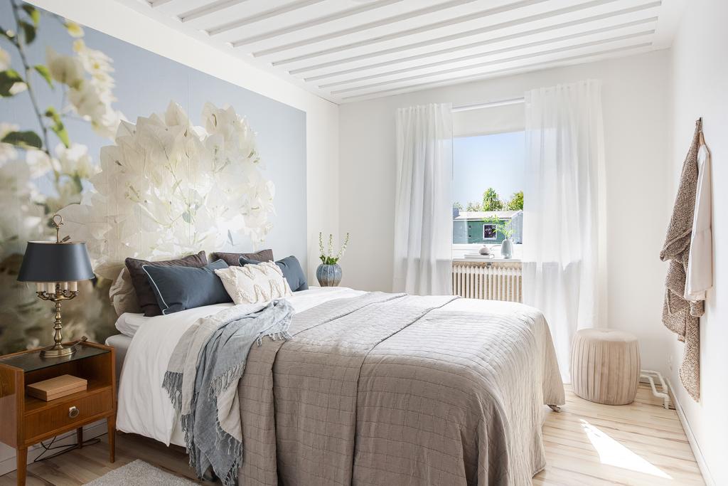 Det stora sovrummet med fönster mot trädgården