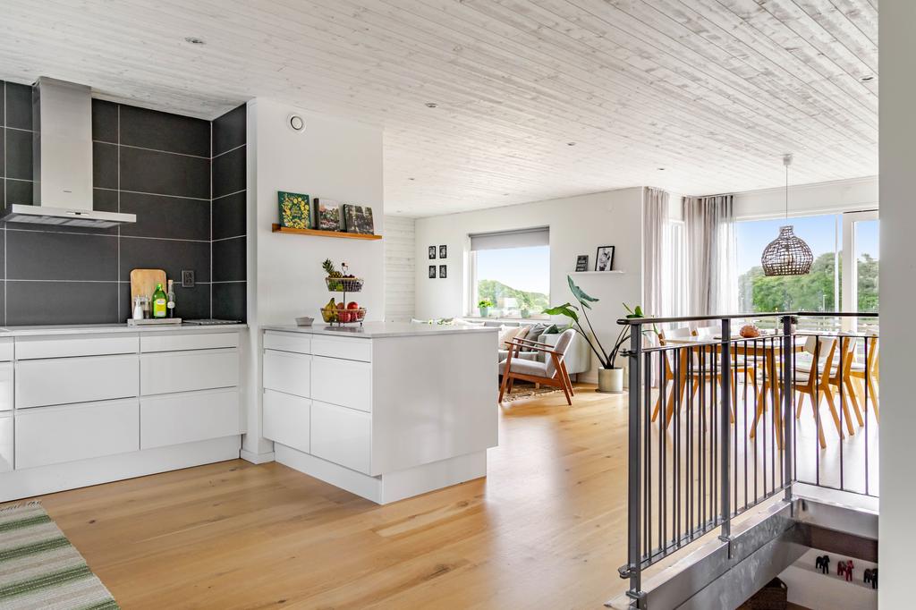 Social och luftig planlösning där kök, matplats och vardagsrum binds samman i ett naturligt flöde. De stora fönsterpartierna släpper in rikligt med ljus och skapar en trivsam atmosfär.