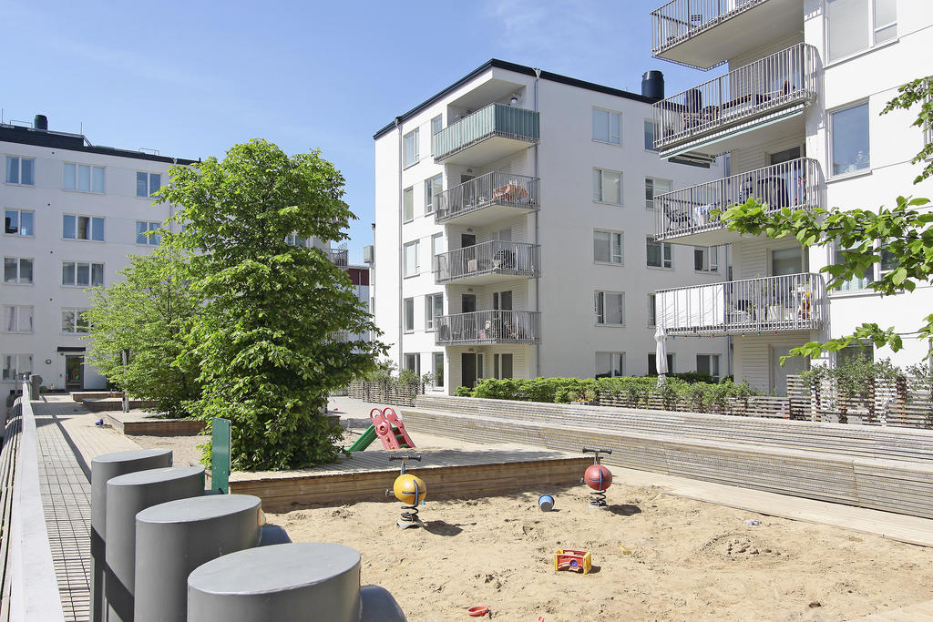 Hamnkranens gård med lekplatser, trädäck och planteringar.