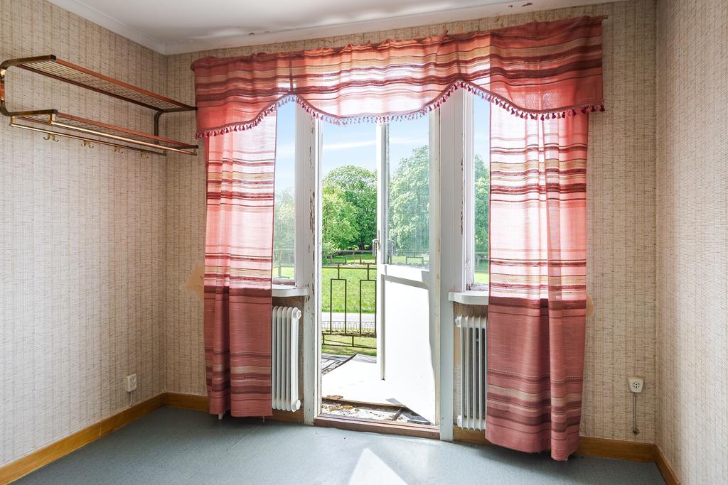 Hallen på andra våning med utgång till balkongen som ligger i kvällsolläge.