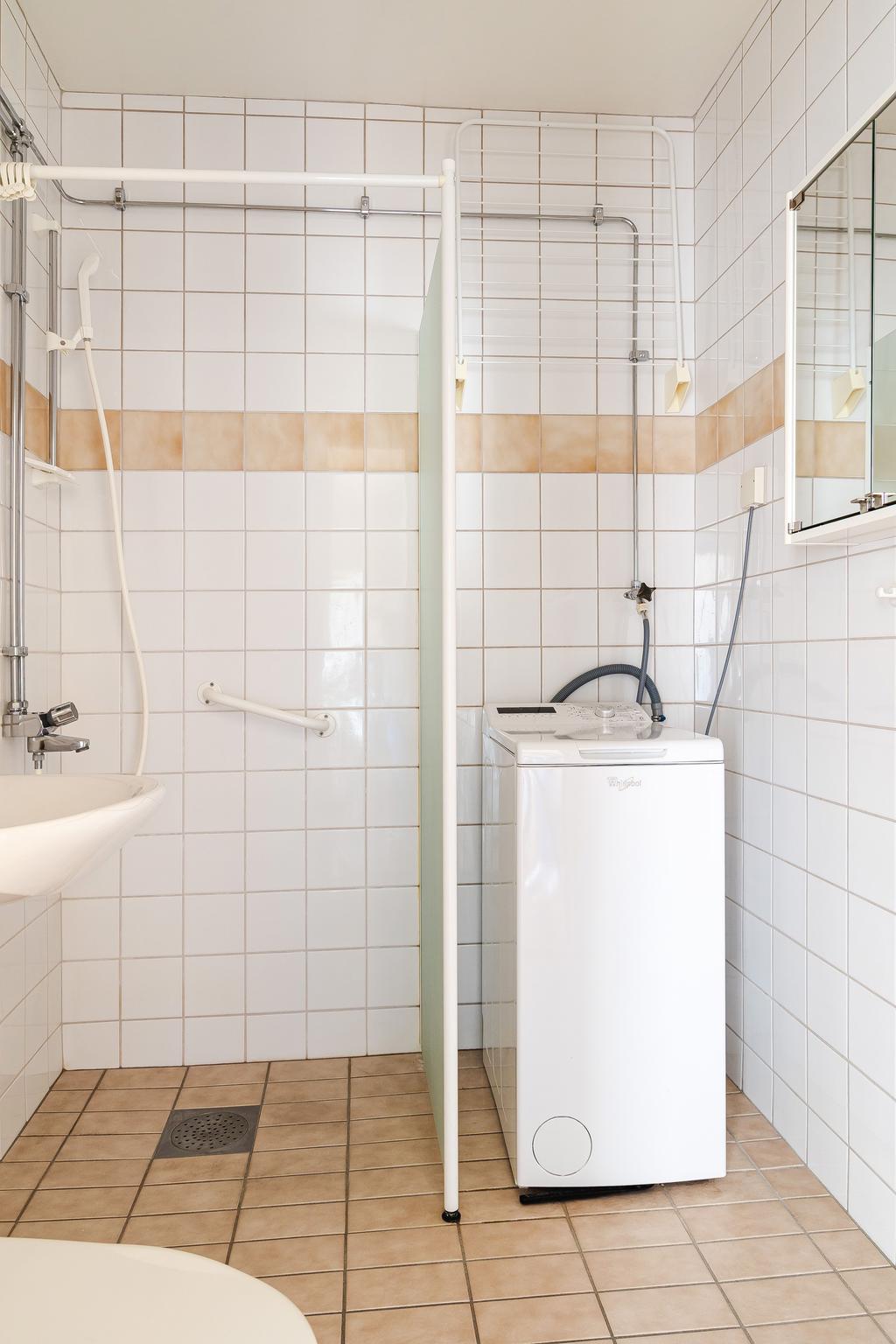 Helkaklat badrum med toppmatad tvättmaskin