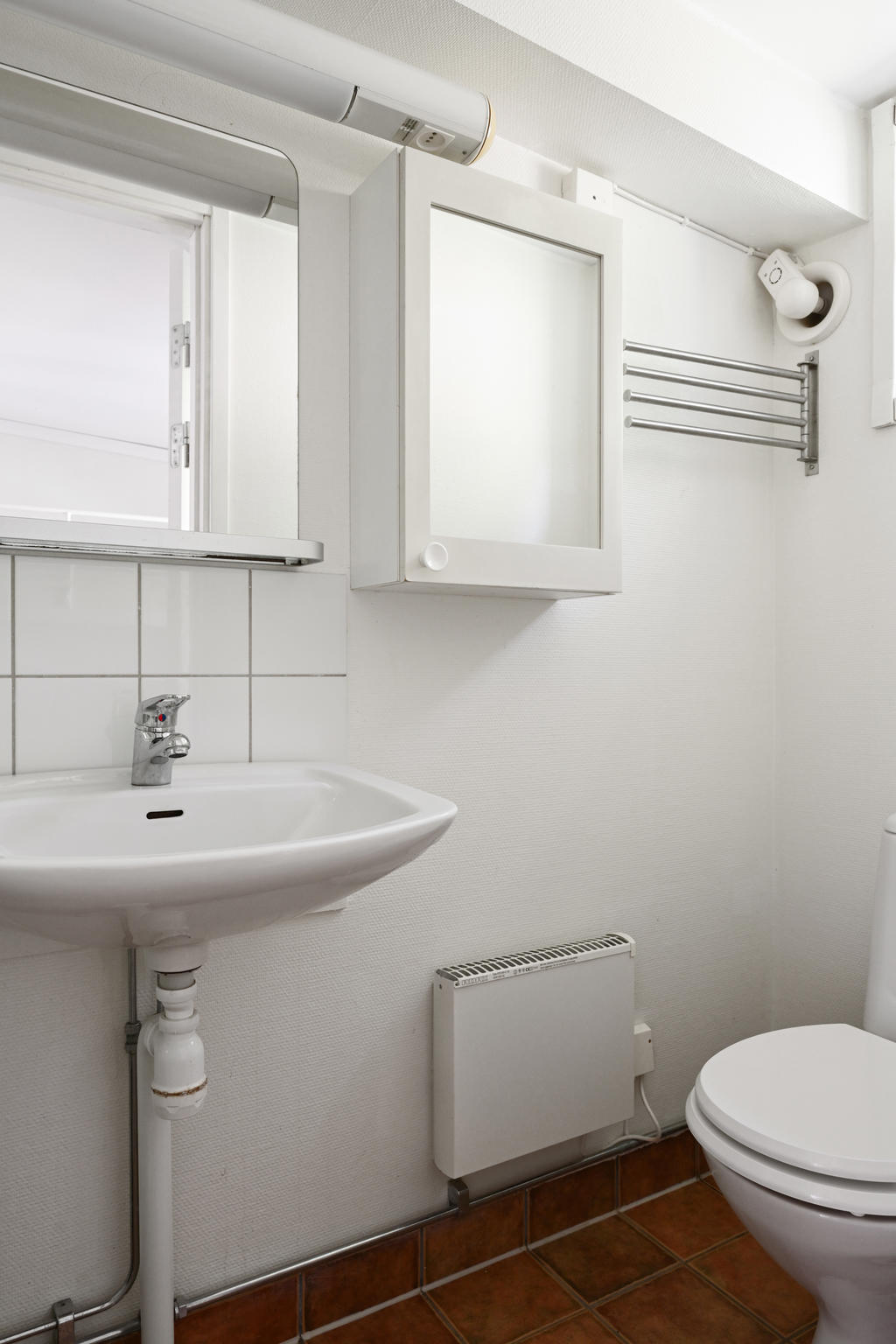 Badrum med toalett, handfat och skåp