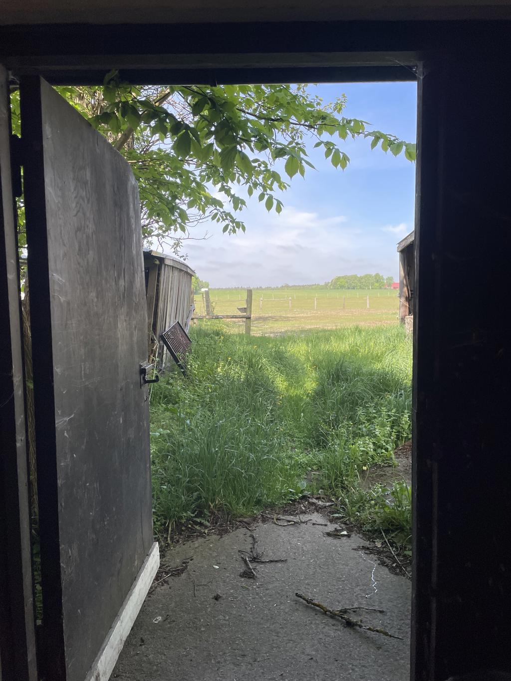 Stalldörr som leder in till stallet och boxarna på ena sidan och på andra sidan kommer man ut mot hagarna & ridhuset 