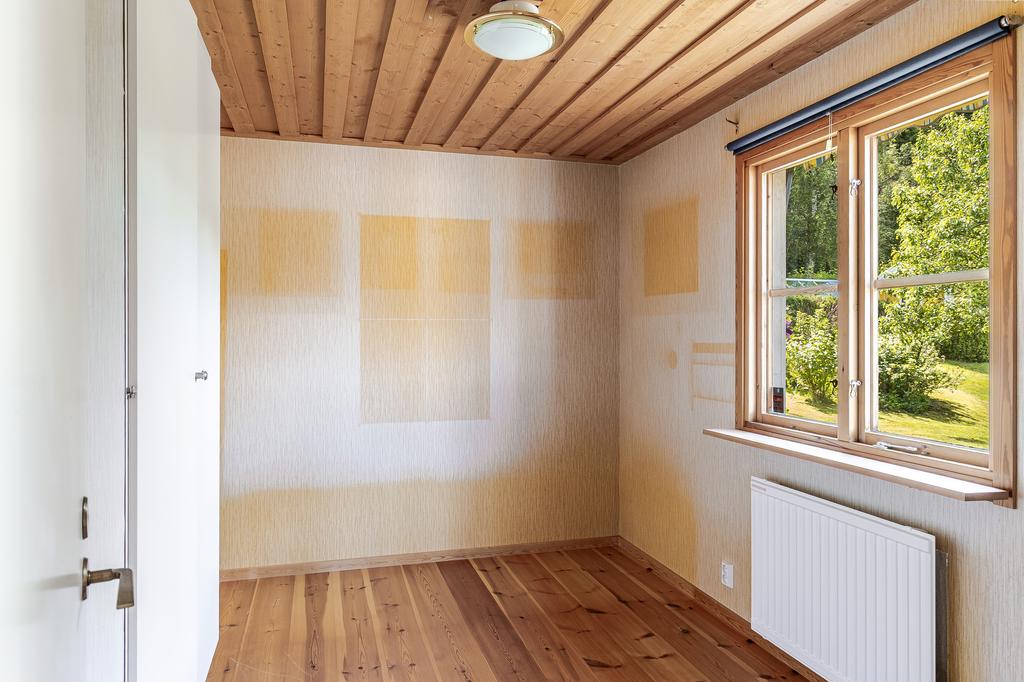 Sovrum med fönster mot uteplatsen och trädgården