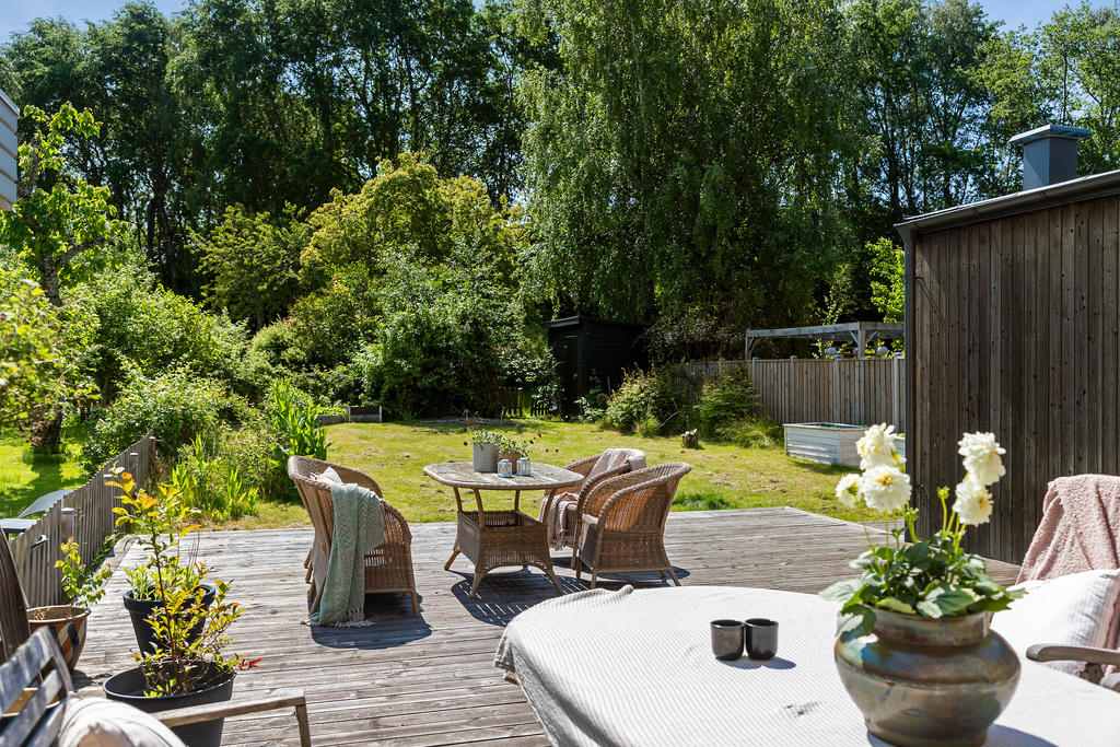 Den södervända trädgården rymmer både altan och plan gräsmatta. Trädgårdarna mynnar ut mot en trygg lekplats där barnen leker med sina vänner