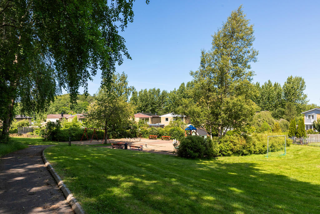 På andra sidan staketet ligger en lummig, lekplats och en fotbollsplan. Ingen biltrafik gör den trygg att leka på 