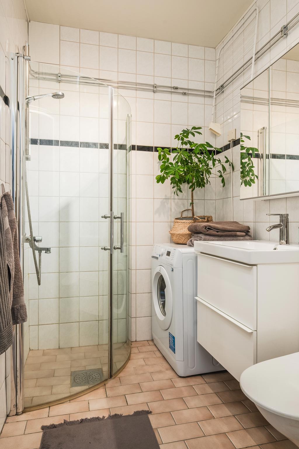 Helkaklat badrum med tvättmaskin installerad