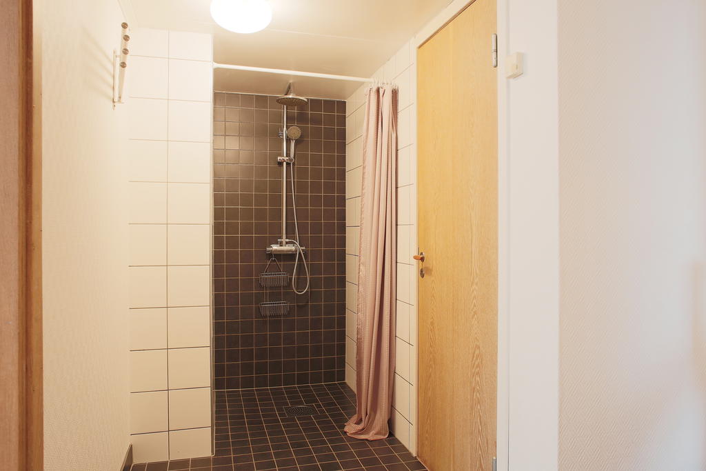 Dusch utanför bastun. Dörr till "pannrum" med fjärrvärmen och plats till förvaring