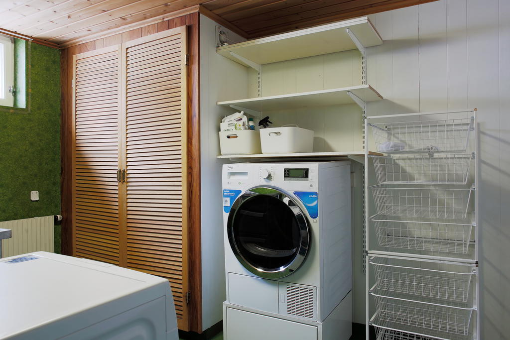 Tvättavdelning med tvättmaskin, torktumlare, ho och plats till förvaring