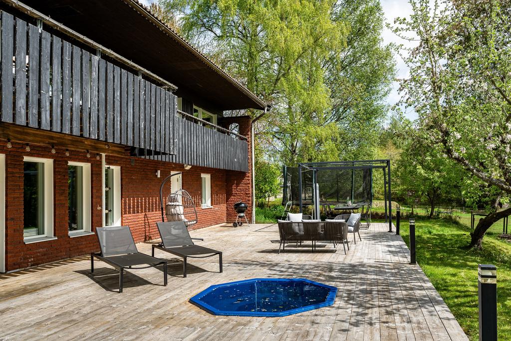 Rymligt altandäck med vedeldad pool