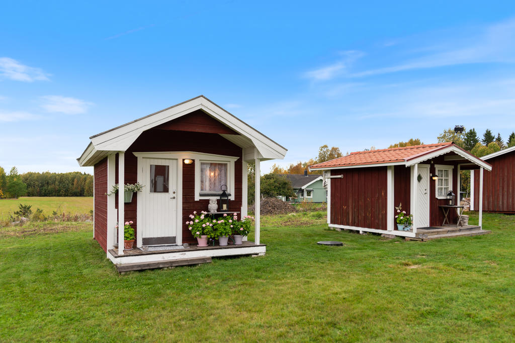 Sovstuga (till vänster i bild), byggnad med dusch och tvättmaskin samt förvaring (till höger i bild)