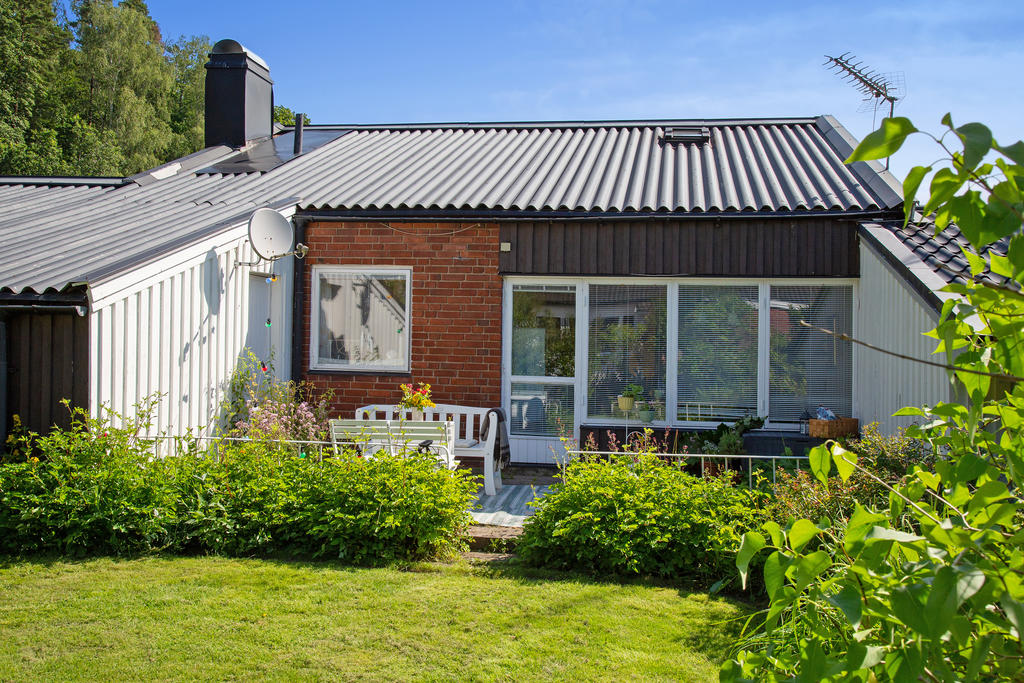 Härlig grönskande trädgård med trevlig uteplats