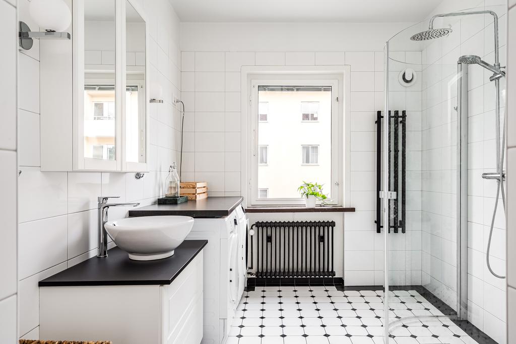 Stort och ljus helkaklat badrum med golvvärme samt tvättmaskin och torktumlare