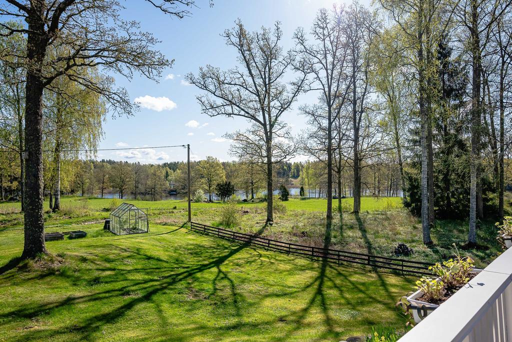 Tomtvy mot växehus och sjön