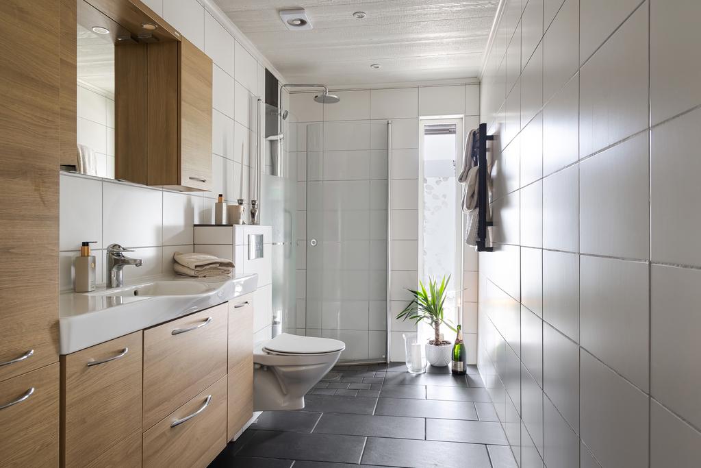 Helkaklat badrum med duschhörna längst in.