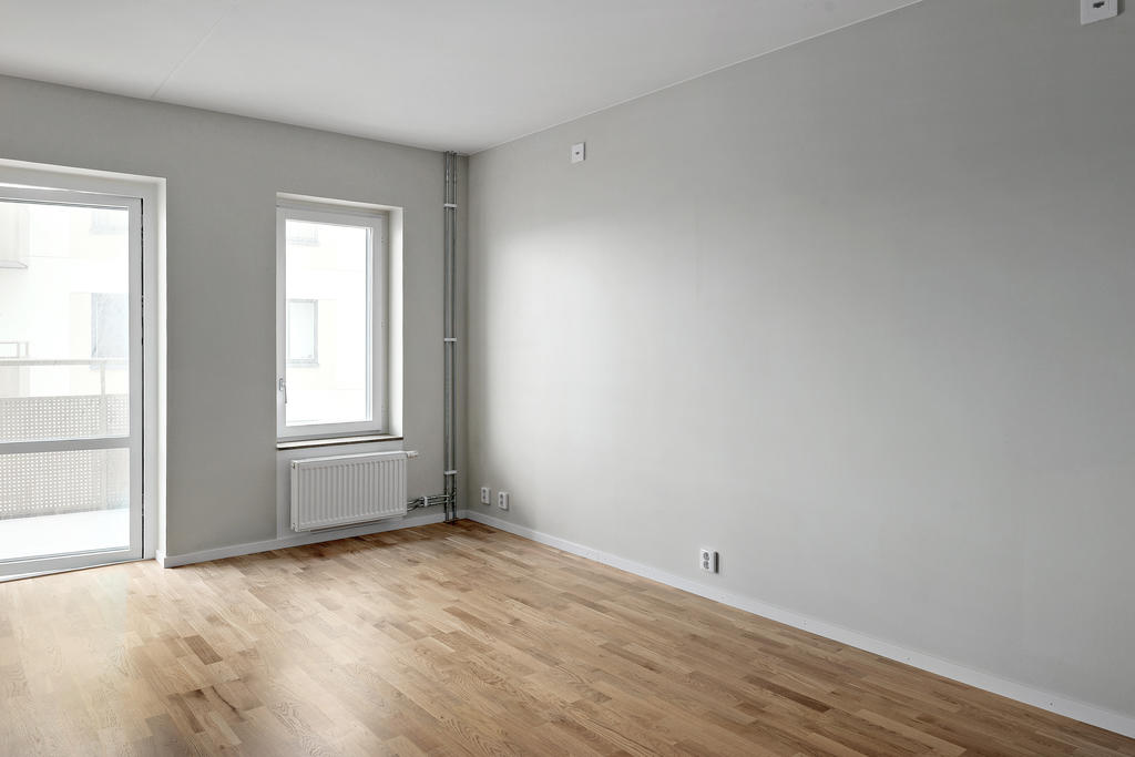 Lättmöblerat allrum med utgång till balkongen.