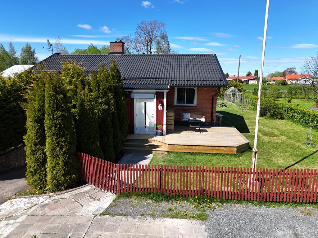 En vackert inramad tomt med trästaket och buskar. 