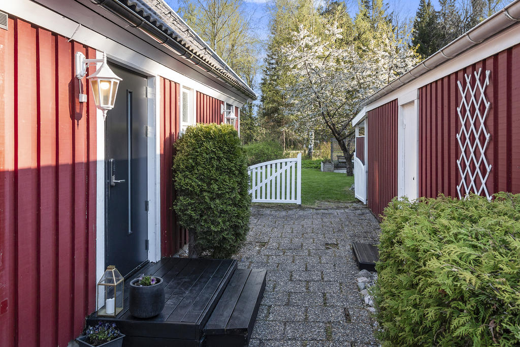 Husets entré i anslutning till tillhörande garage/förråd 