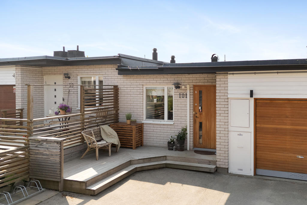 Framsidan erbjuder också en uteplats. Tidstypisk stil på dörr och garageport