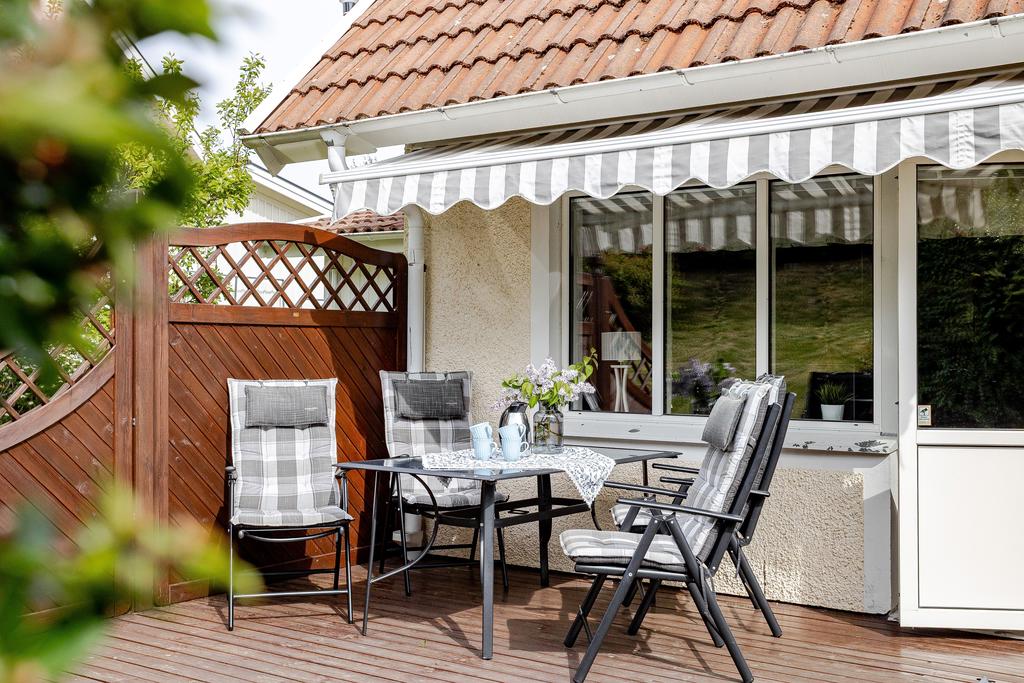 Altanen är en inbjudande plats med plats för trevliga fikastunder, skyddad av en charmig markis och omgiven av insynsskyddande trästaket för extra lugn och avskildhet