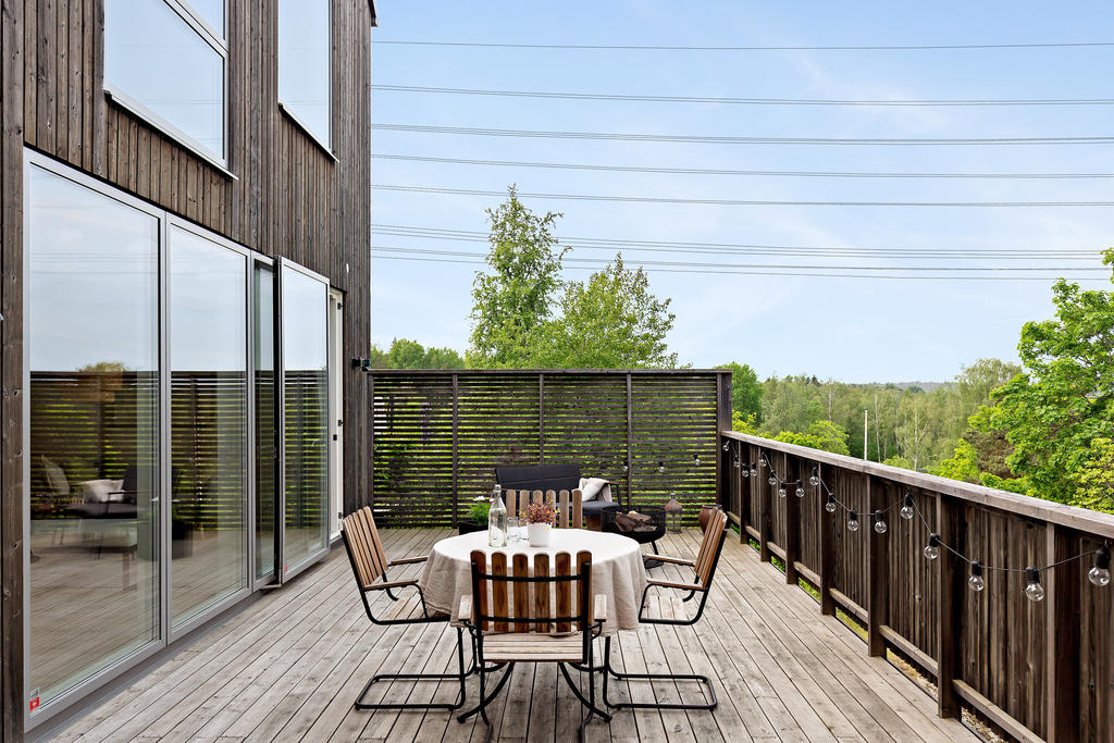Superhärlig terrass mot himmel och grönska
