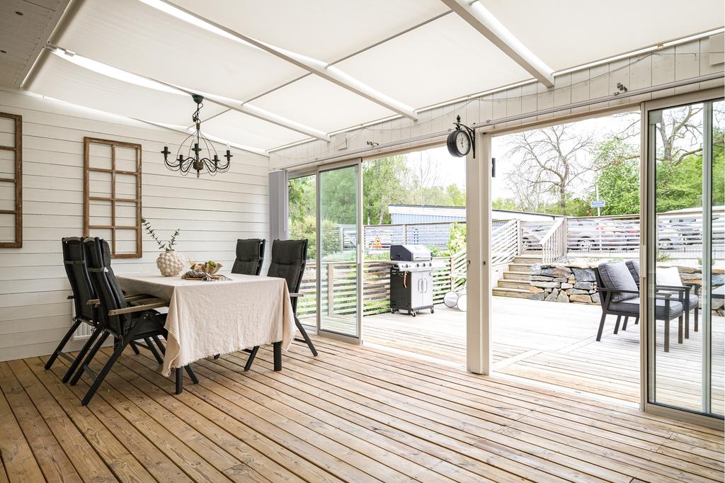 Det stora ljusa uterummet med skjutdörrar öppnar upp så fint till bostadens uteplats där ute/inne-känslan suddas ut.