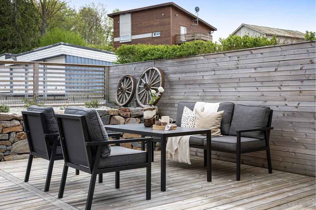 Altanen med sitt skyddande plank, ger perfekt lä och insynsskydd. Den vackra muren med sin plantering täckt av vita fina stenar och vackra rosor, är en fröjd för ögat. Kvällstid lyser alla spotlights upp uteplatsen så fint och effektfullt.