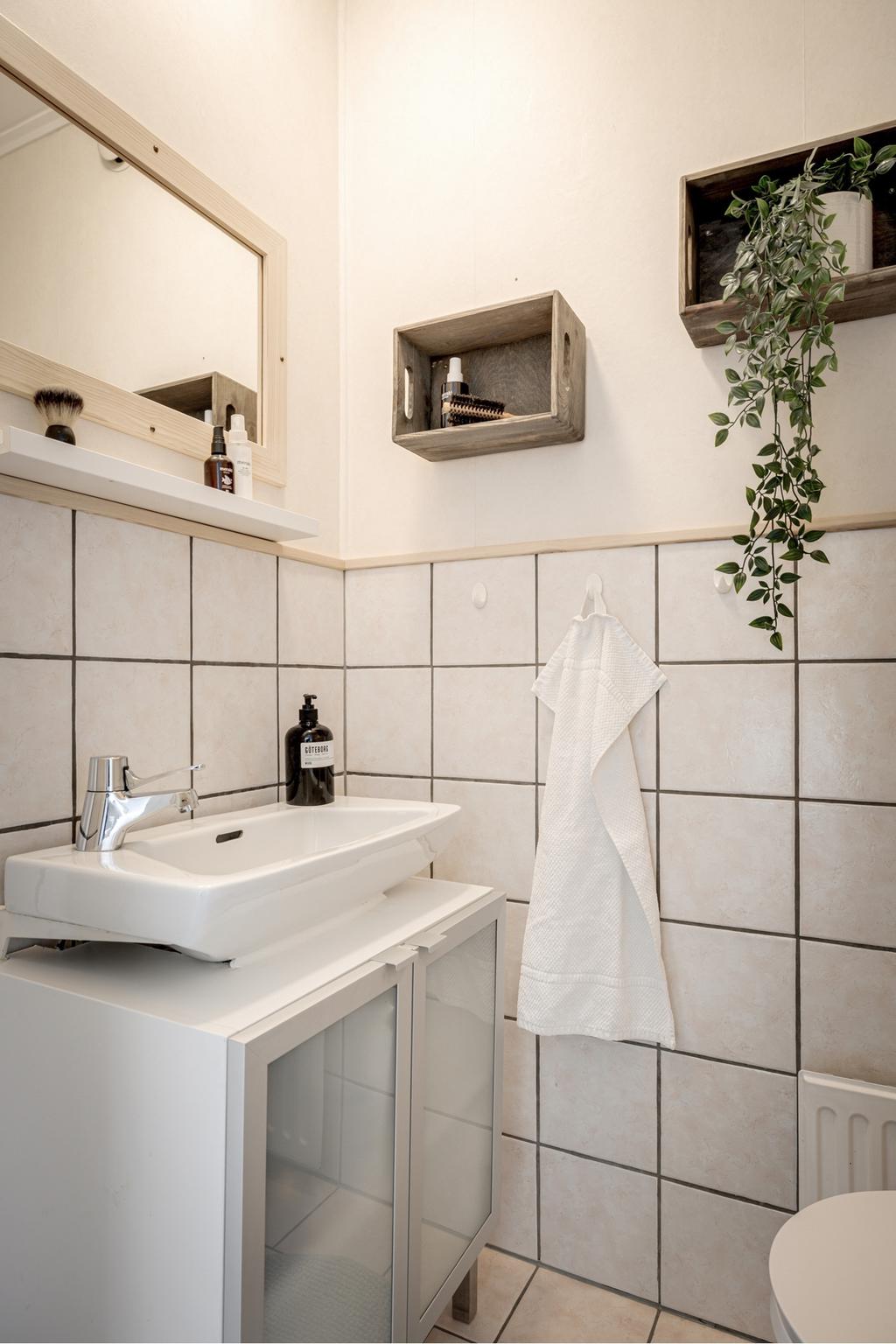 Gästtoaletten på entréplan i ljuv beige/rosa kakel och klinker.