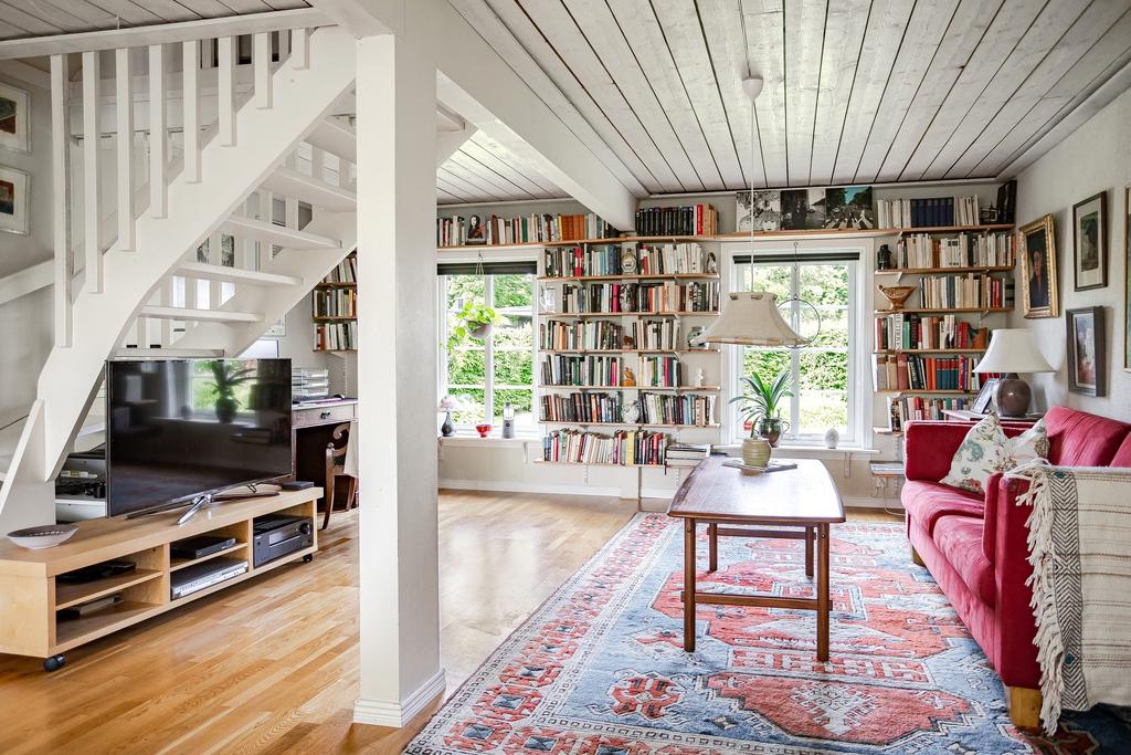 Den äldre delen av huset fungerar idag som ett extra vardagsrum med generösa ytor, vacker utsikt mot trädgården från båda håll och en mysig kamin. 