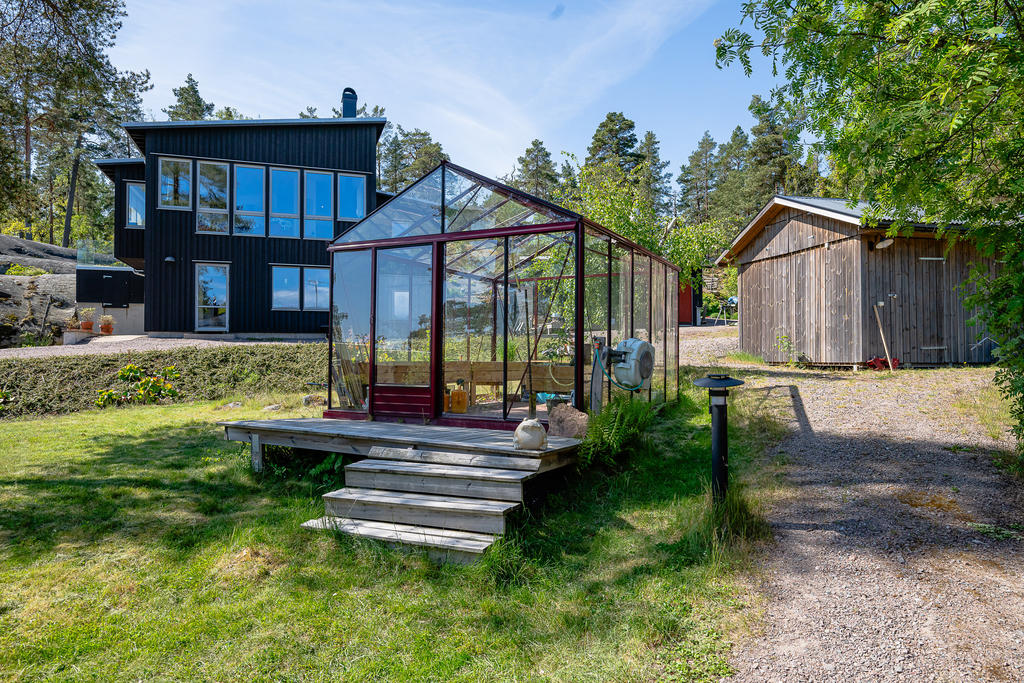 Växthus, förråd och grannens hus