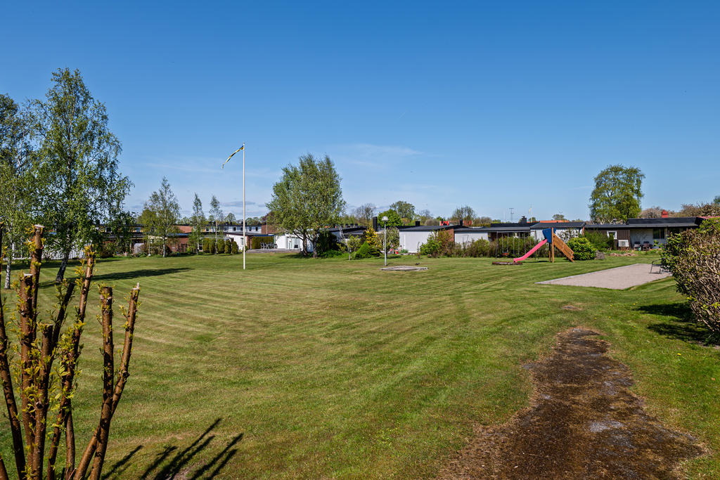 Samfällighetens grönområde med lekplats, boulebana och gott om plats för utelek för barnen.