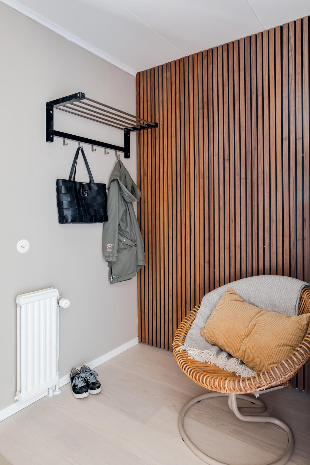 Inbjudande hall med enstavs-parkett, målade väggar och akustikpanel.