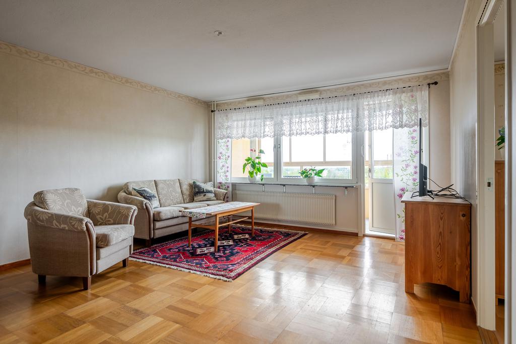 Vardagsrummet med utgång till den stora inglasade balkongen. 