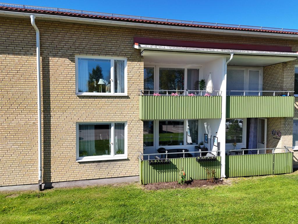 Uteplats i markplan där du har en grind i balkongräcket vilket tar dig direkt ut på gräsmattan.