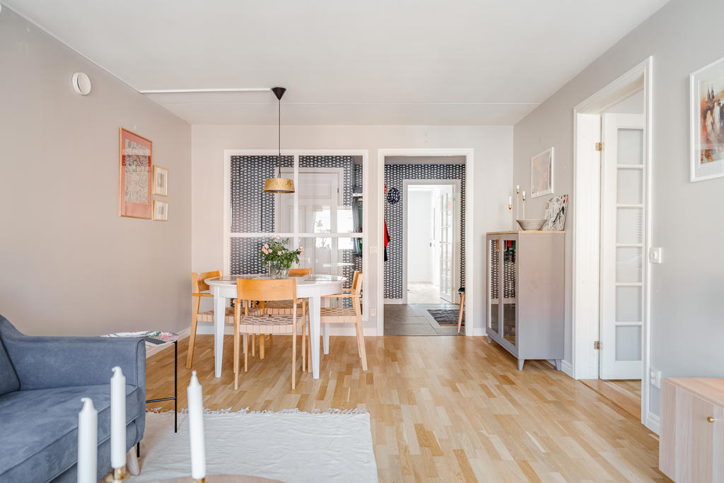 Stort smafullt vardagsrum med fint ljusinsläpp och utgång till den inglasade balkongen.