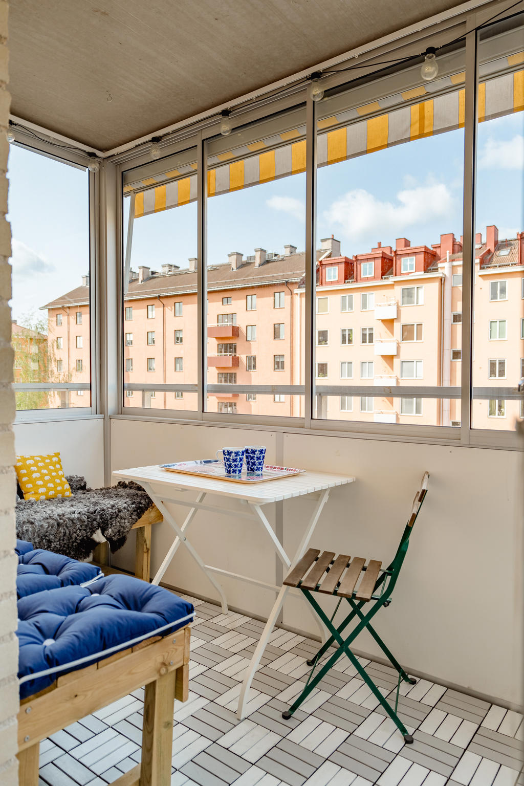 Inglasad balkong i högt västerläge med markis.