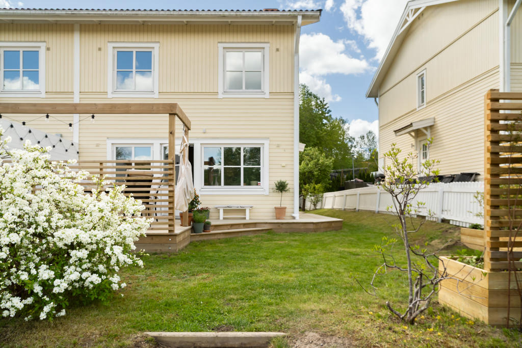 Välplanerad baksida med  bra uteplats, odlingsbäddar och plats för lek på gräsmattan