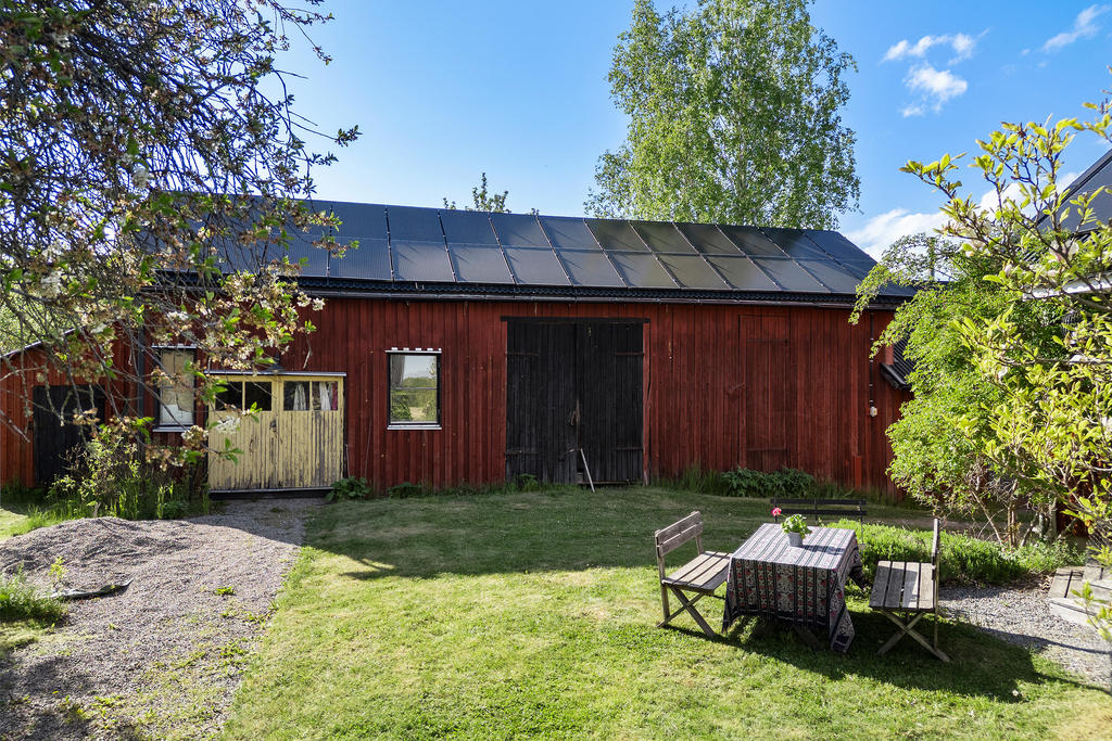 Ladan med vedbod, kontor/verkstad (gula portar), loge (svarta portar) samt garage längst till höger