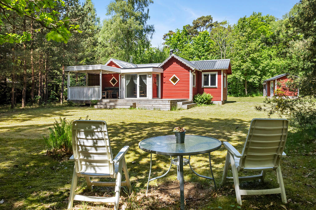 Ett hem som öppnar upp mot naturen med trädäck och uterum.