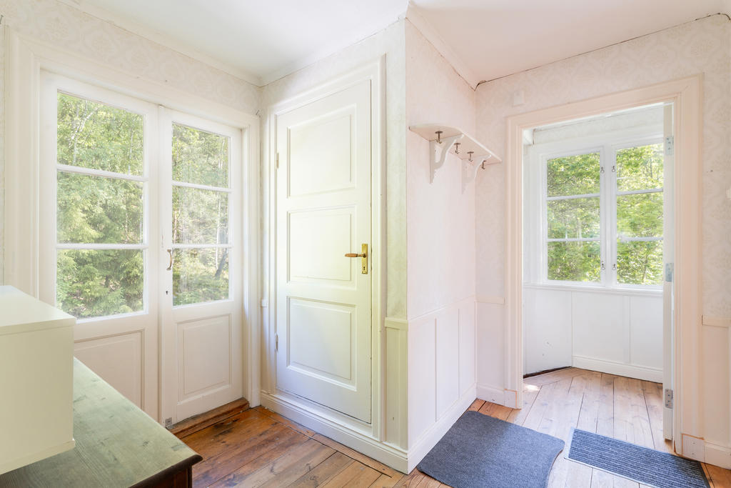 Hall med balkongdörrar och dörr till vind