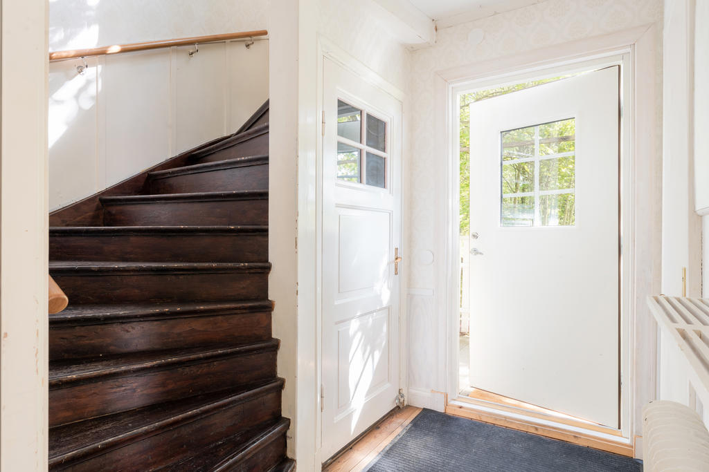 Hall med trapp till övervåning och dörr till källare